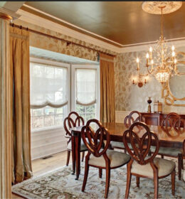 A Wooden Dining Table Under a Golden Theme Chandelier