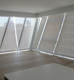 An Inclined Window With White Color Drapes