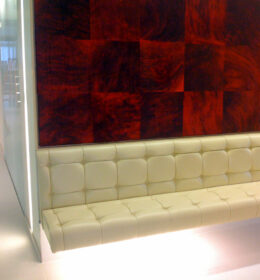White Paneled Cushion Seating Space With Red and Black Wall