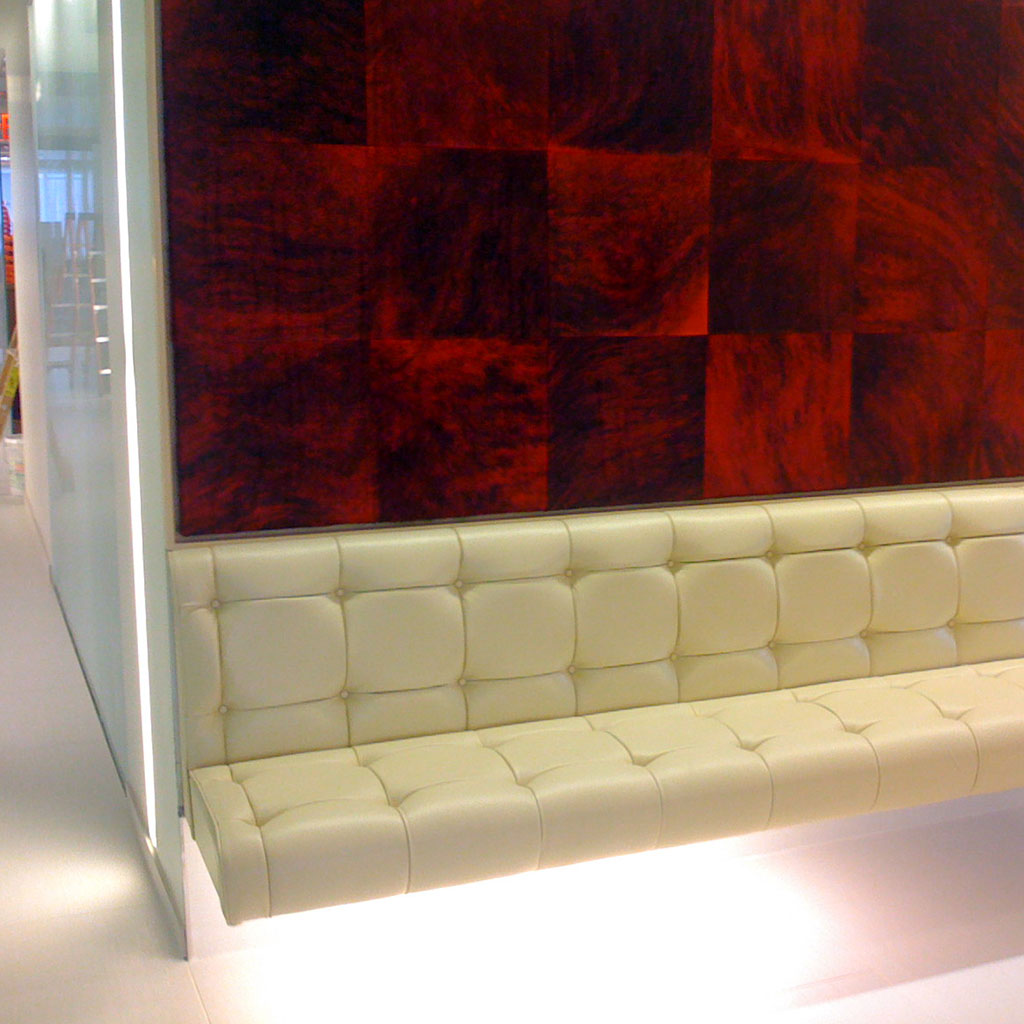 White Paneled Cushion Seating Space With Red and Black Wall