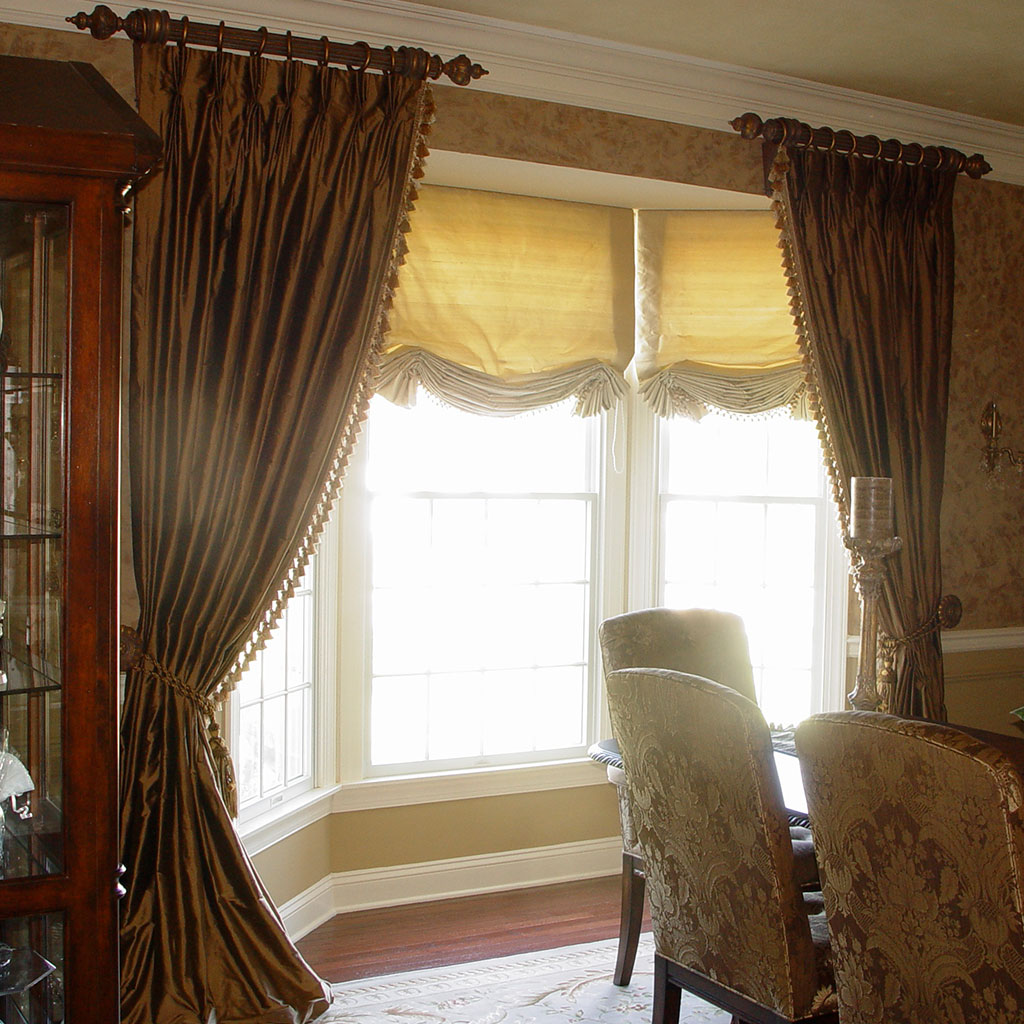 A Window With Gold Color Curtains by a Bay Window Space