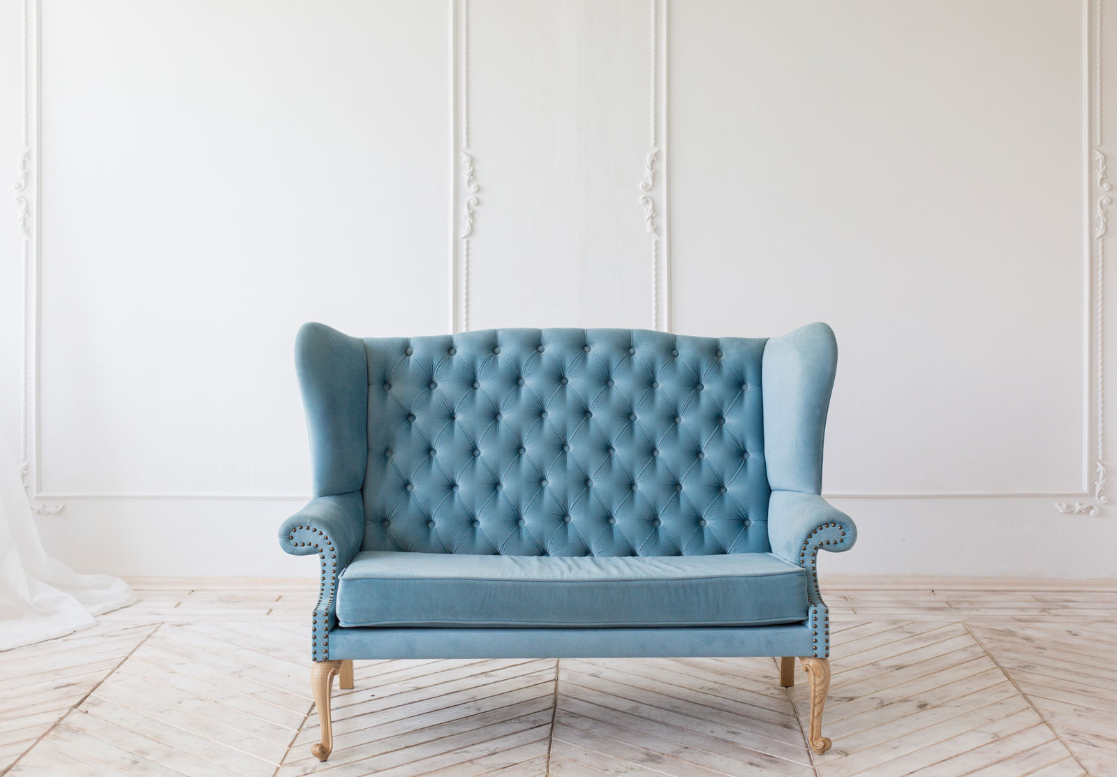 A Baby Blue Color Paneled Cushion Sofa in a White Background