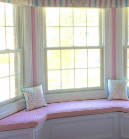 A Bay Window Seating Space With Pink Cushions